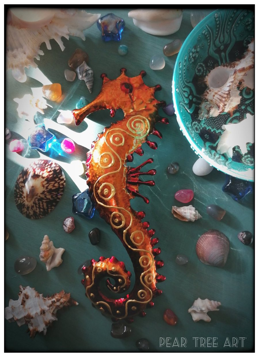 Orange and red  metal Seahorse wall decoration. Made from a coffee tin.