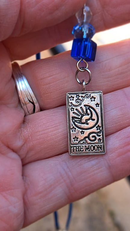 The Moon tarot pendant on a blue rope necklace.,