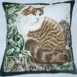 fluffy tabby and white cat sitting on a garden fence cushion