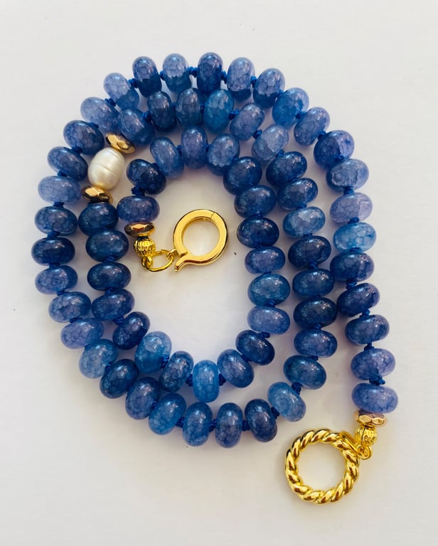 Denim blue cracked glass rondelles, hand knotted with a pearl focal bead 