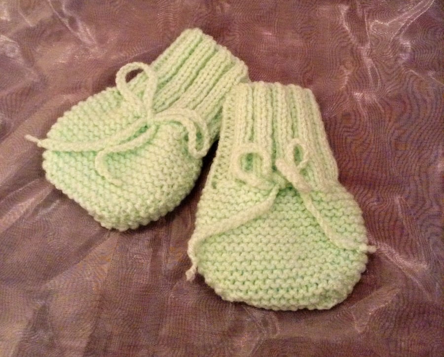 Little knitted green baby mittens
