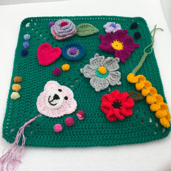 A Twiddle Mat for Active Hands. A Crocheted Fiddle Square with Bright Flowers.