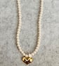 Cream beaded necklace with large gold heart