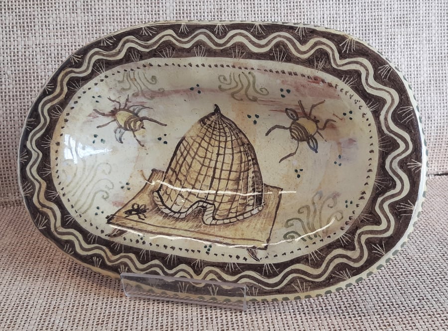Oval slip ware dish with hand painted bee skep