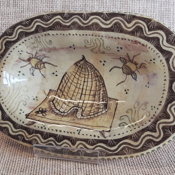 Oval slip ware dish with hand painted bee skep