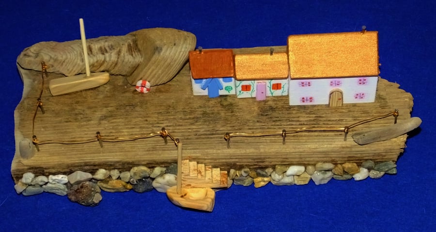 Quayside fishing village scene made from driftwood from Cornwall with dingy.