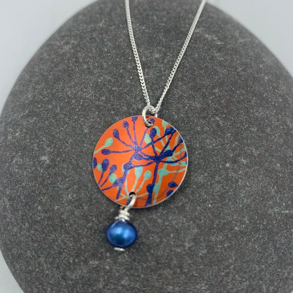 Orange and blue aluminium cow parsley circle pendant with pearl 