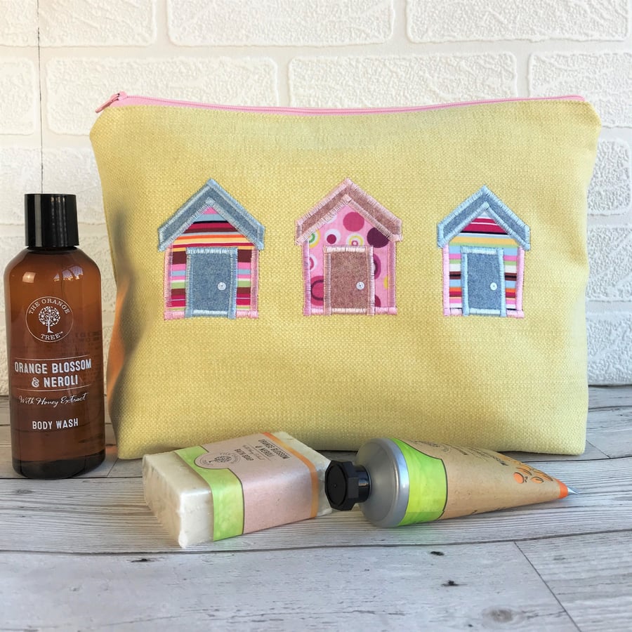 Beach huts toiletry bag, wash bag in yellow fabric with three bright beach huts 