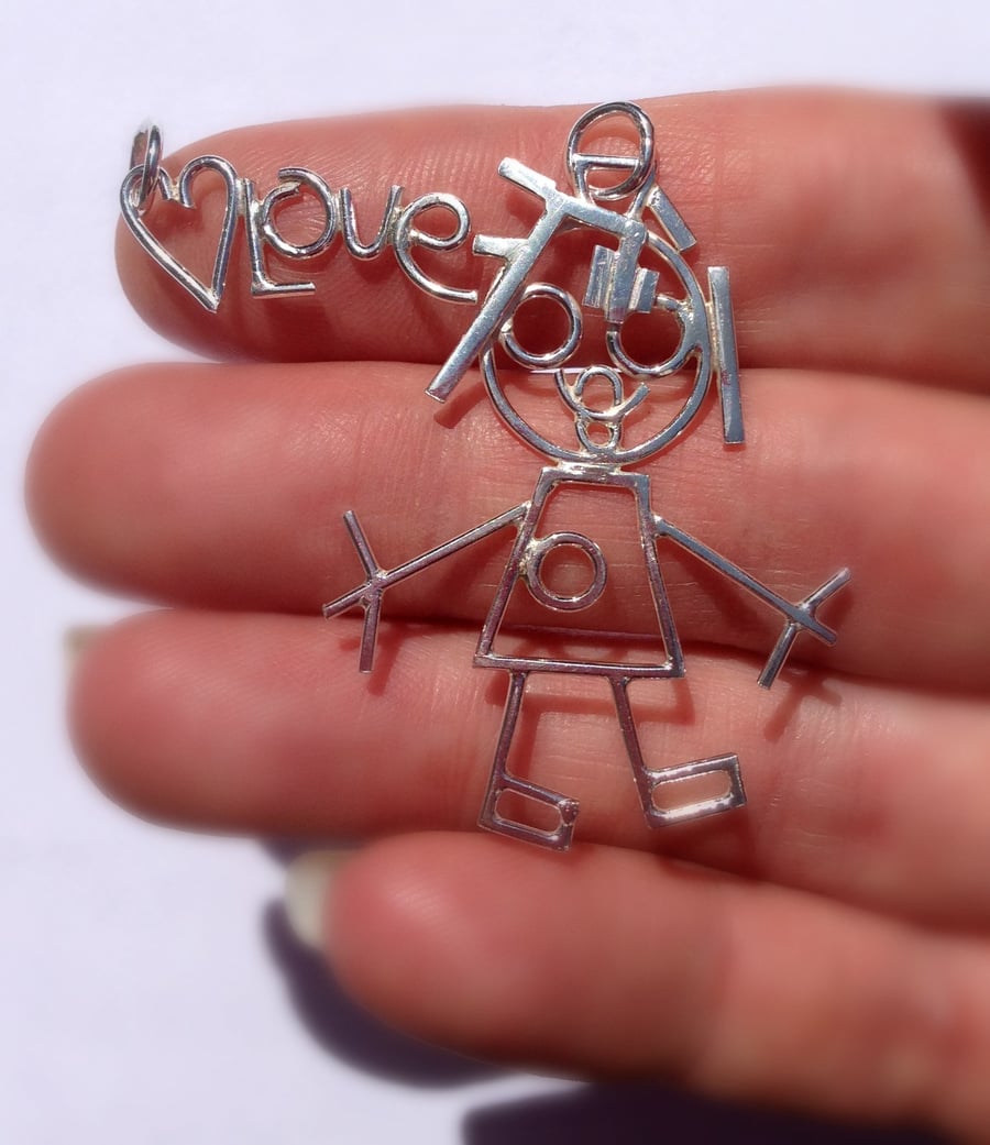The girl with the rubber band hair. A silver pendant from a childs drawing.