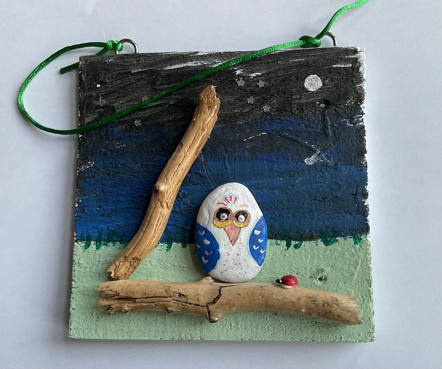 Painted pebble owl on a branch