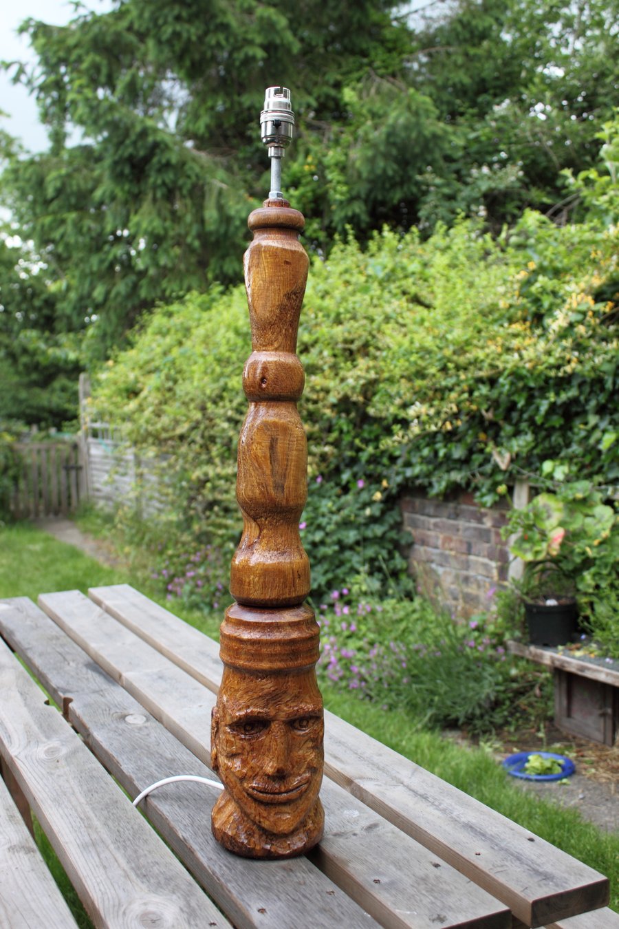 Eucalyptus side lamp with a carved face.