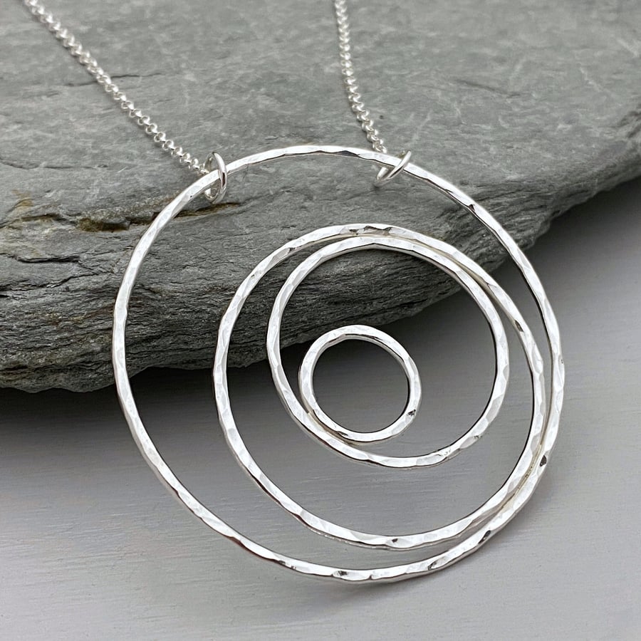 Large round silver statement necklace handmade from hammered silver circles.