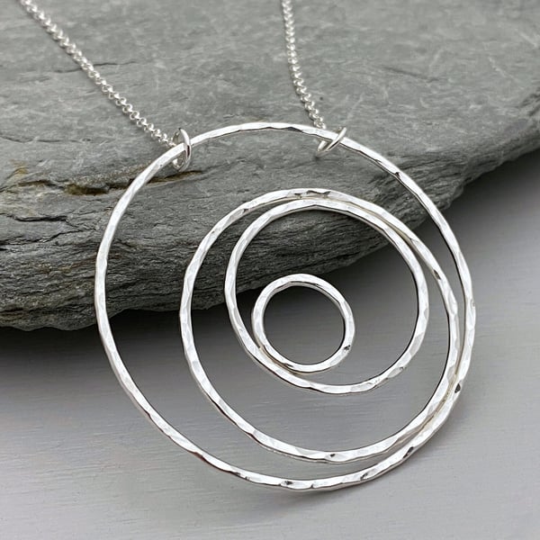 Large round silver statement necklace handmade from hammered silver circles.