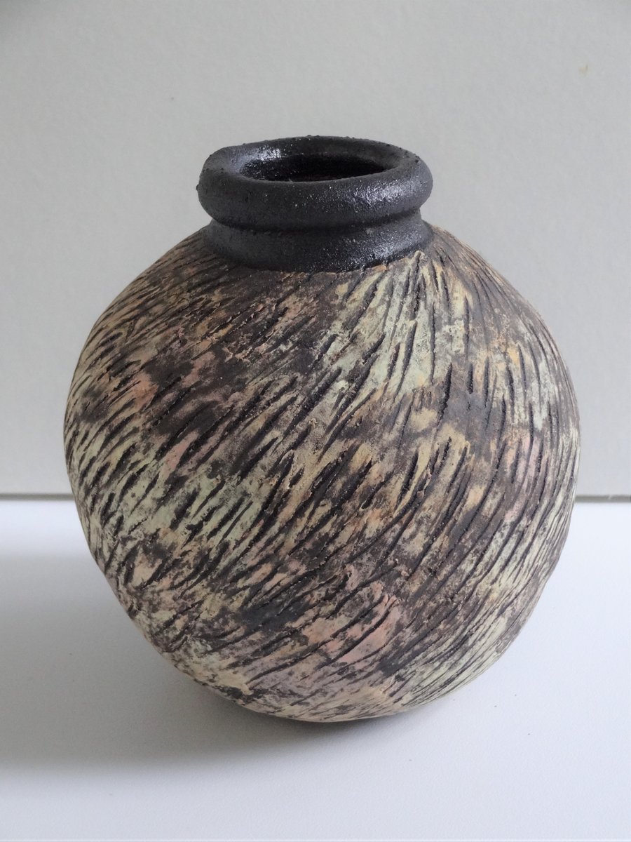 Ceramic moon jar pottery. Pastel colour decoration on black stoneware clay.  