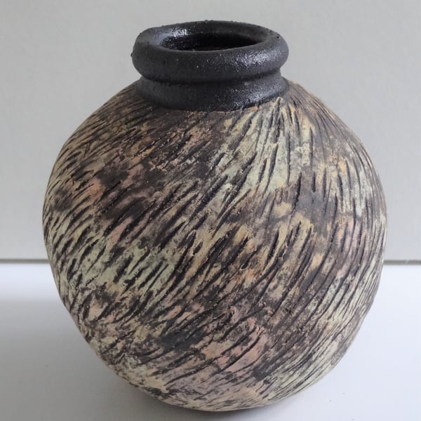 Ceramic moon jar pottery. Pastel colour decoration on black stoneware clay.  