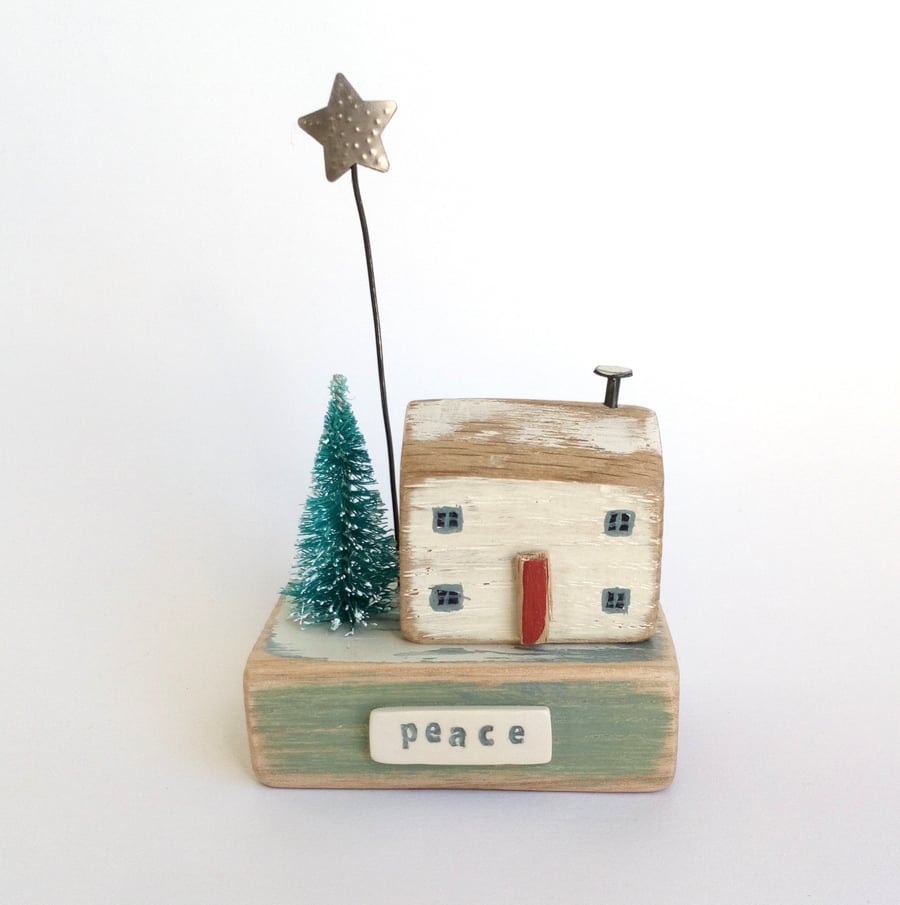 Little wooden house with Christmas tree and star