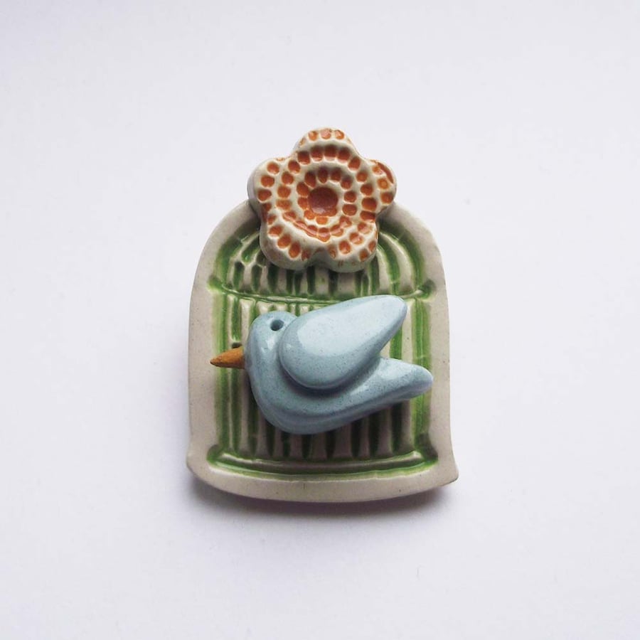 Little ceramic bird cage brooch with flower. Pottery jewellery