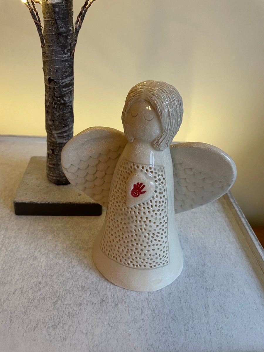 Angel sculpture with red hand symbol