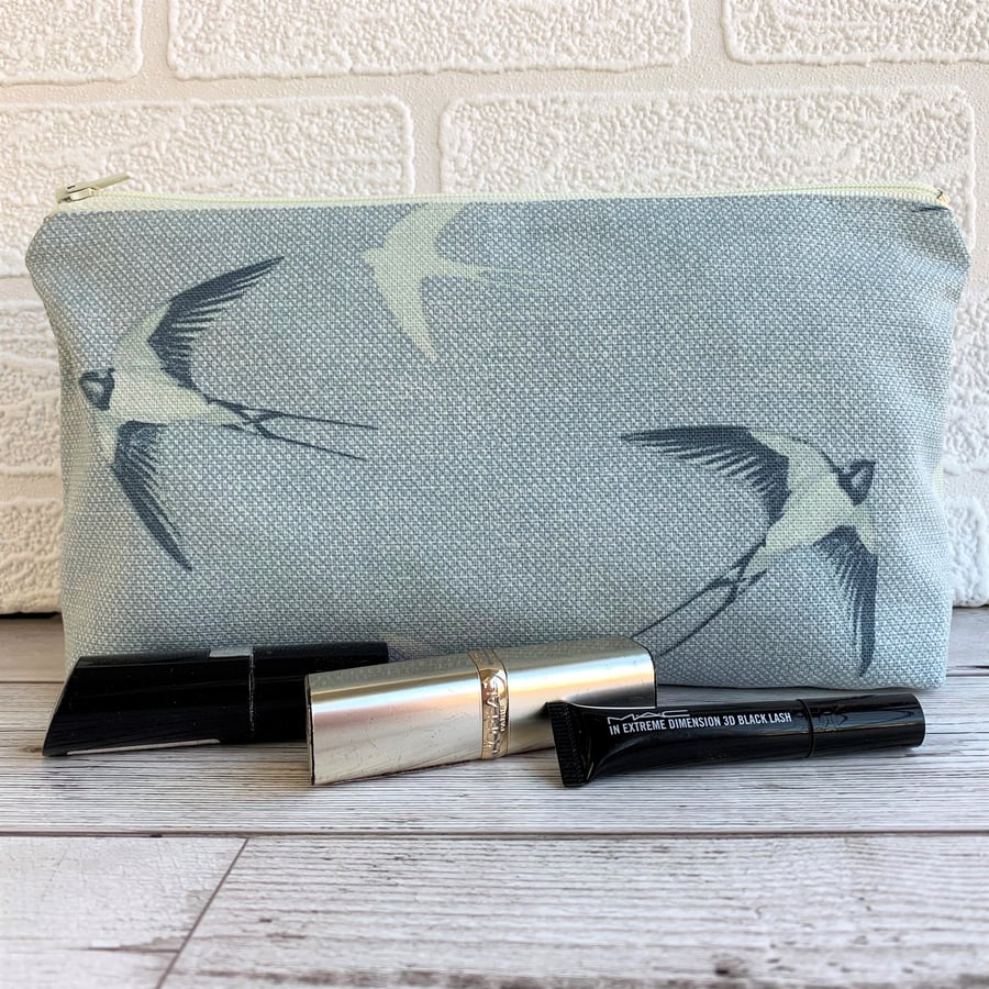 Blue make up bag with swallows in flight print pattern