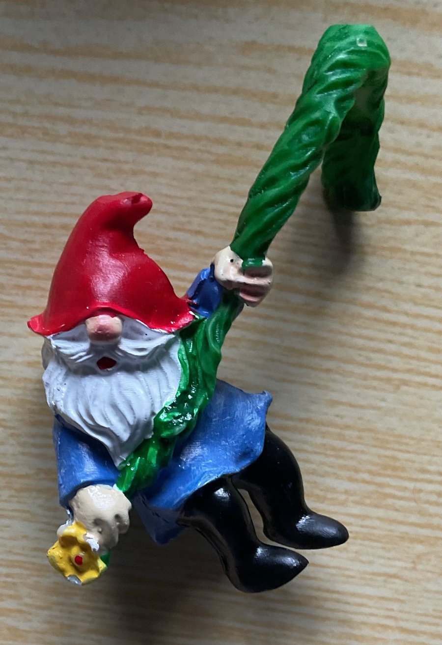 A gnome hanging from a balloon to visit at Christmas . He is hanging on for life
