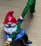 A gnome hanging from a balloon to visit at Christmas . He is hanging on for life