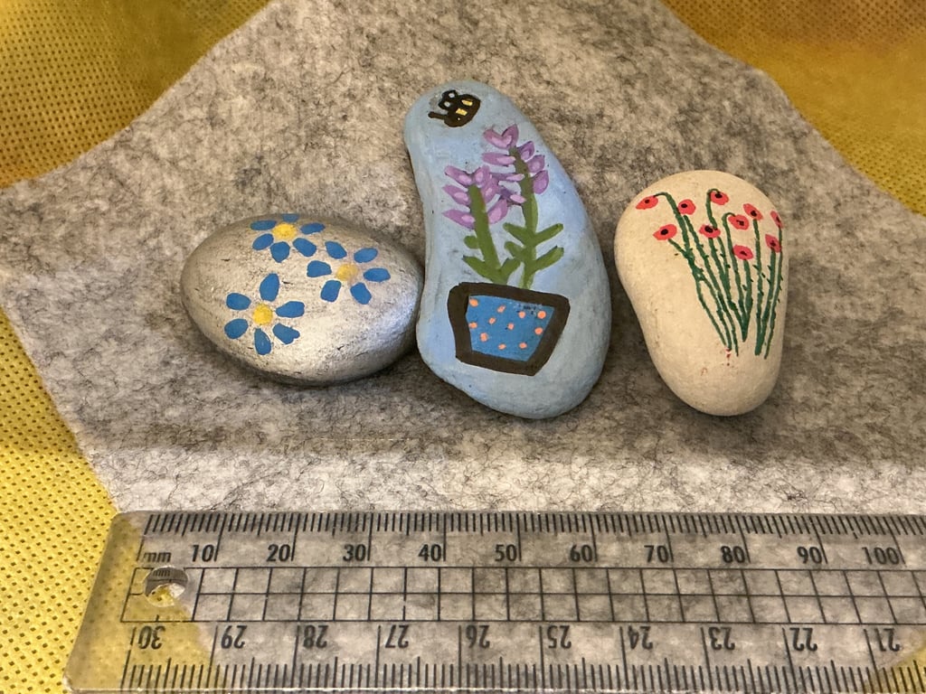 Set of 3 hand painted pebbles with floral designs.