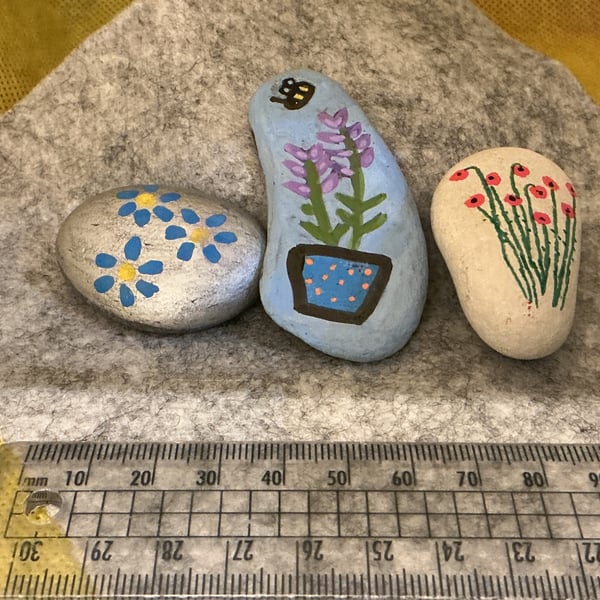 Set of 3 hand painted pebbles with floral designs.