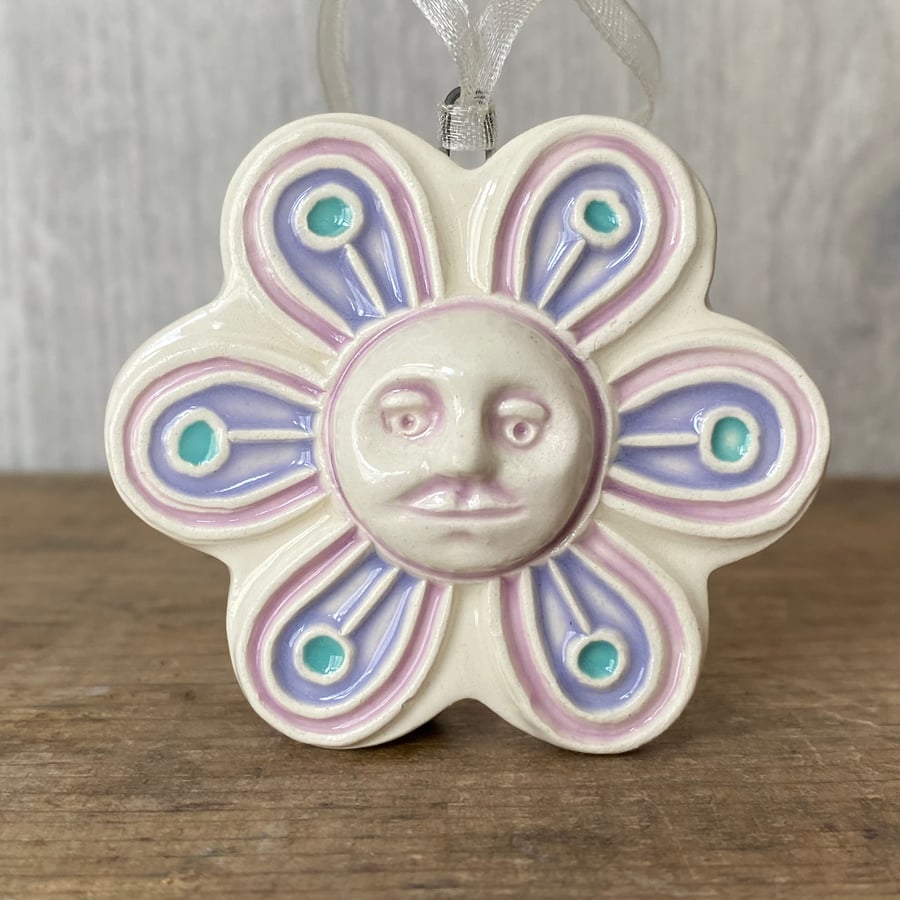 Intricate ceramic flower decoration with face lilac