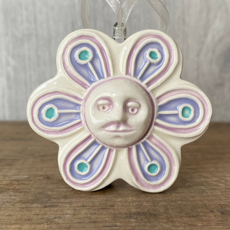 Intricate ceramic flower decoration with face lilac