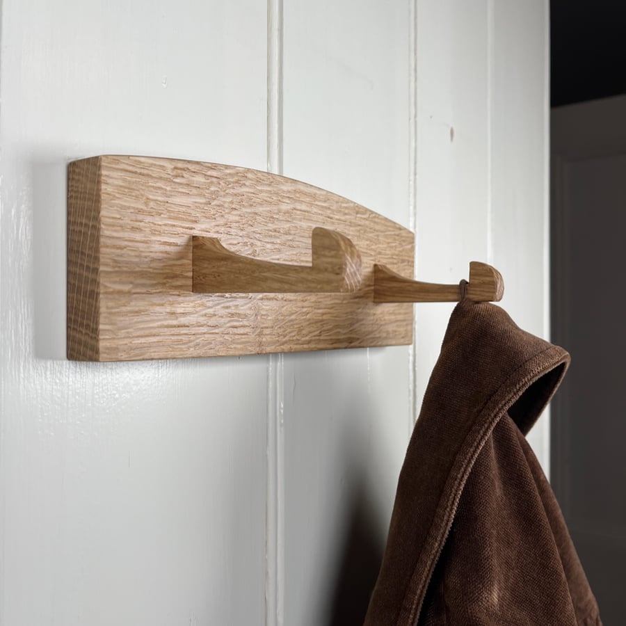 Solid oak coat hooks with two hand carved hooks.