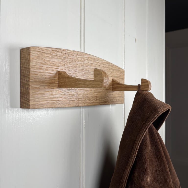 Solid oak coat hooks with two hand carved hooks.