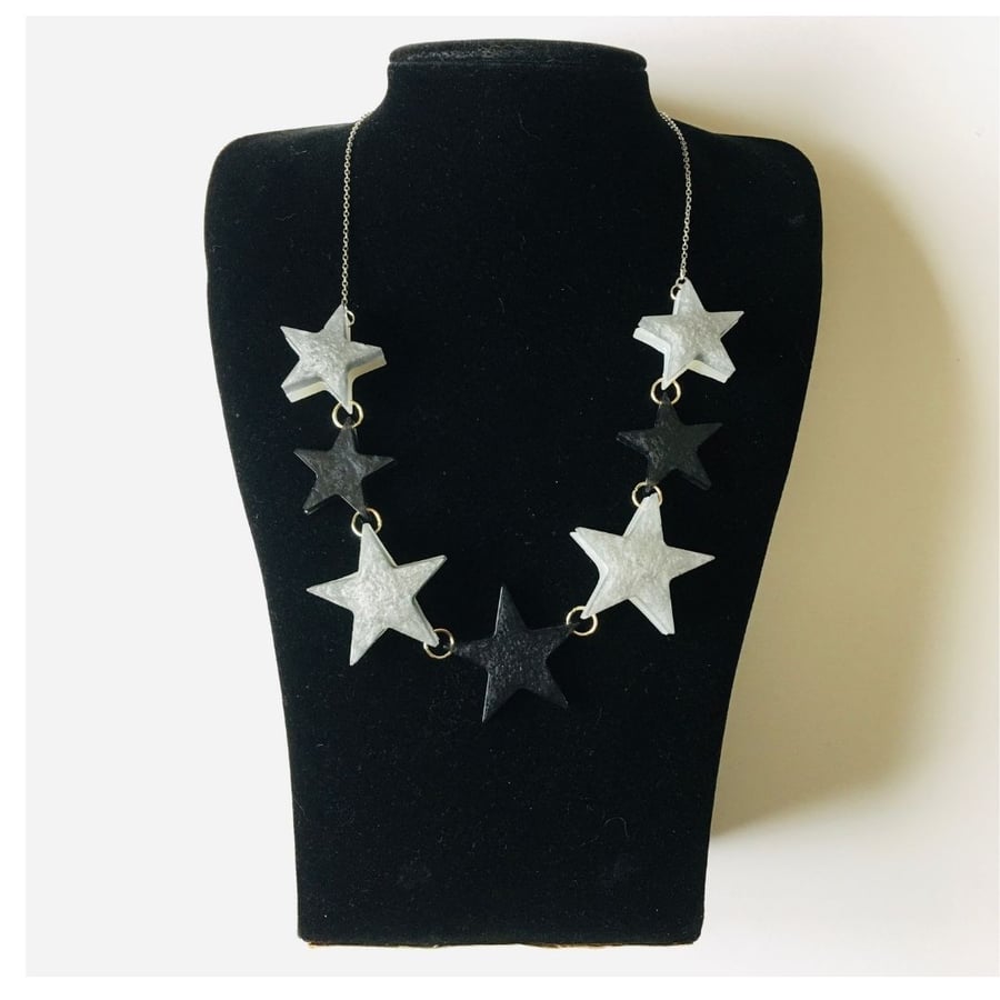 Silver and glitter graduated star necklace with silver plated chain.