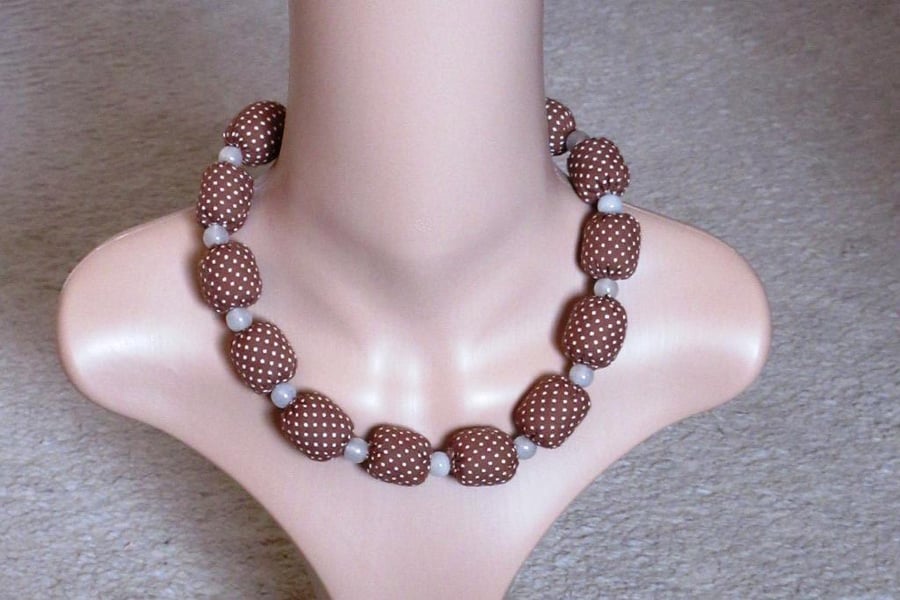 A necklace of beads made from brown and cream spotted cotton fabric