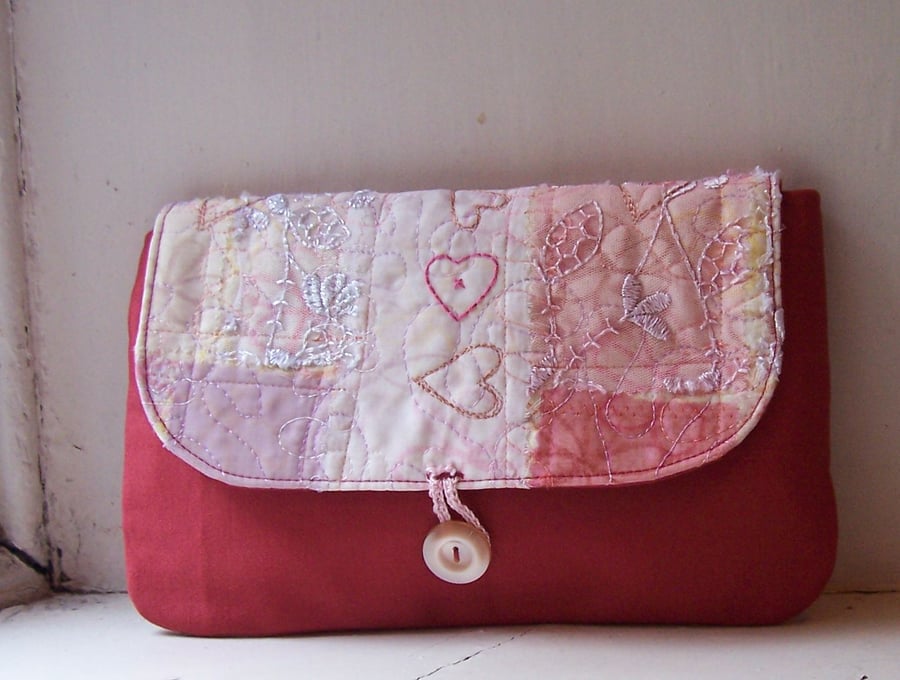 Soft fabric clutch bag in red and pink, with hand embroidery