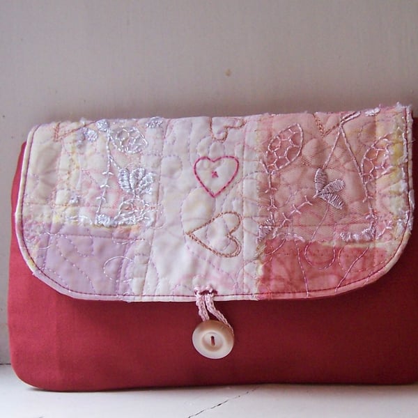 Soft fabric clutch bag in red and pink, with hand embroidery