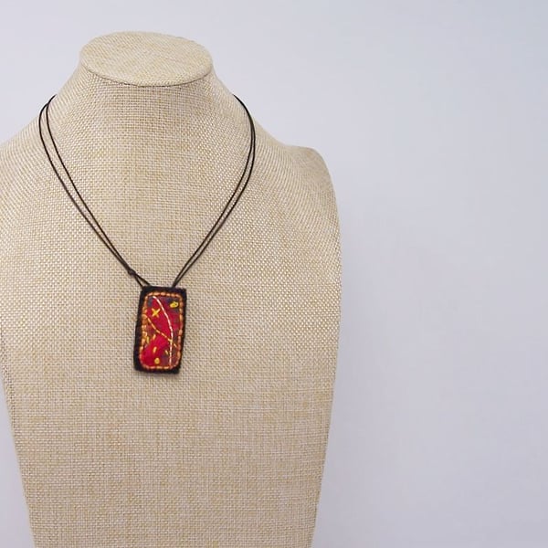Embroidered silk textile necklace in fire colours.