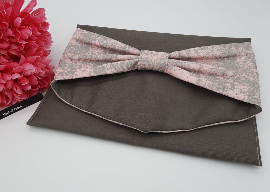 Bow clutch bag in grey denim with pink silver glitter lining. 