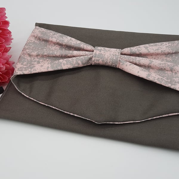 Bow clutch bag in grey denim with pink silver glitter lining. 