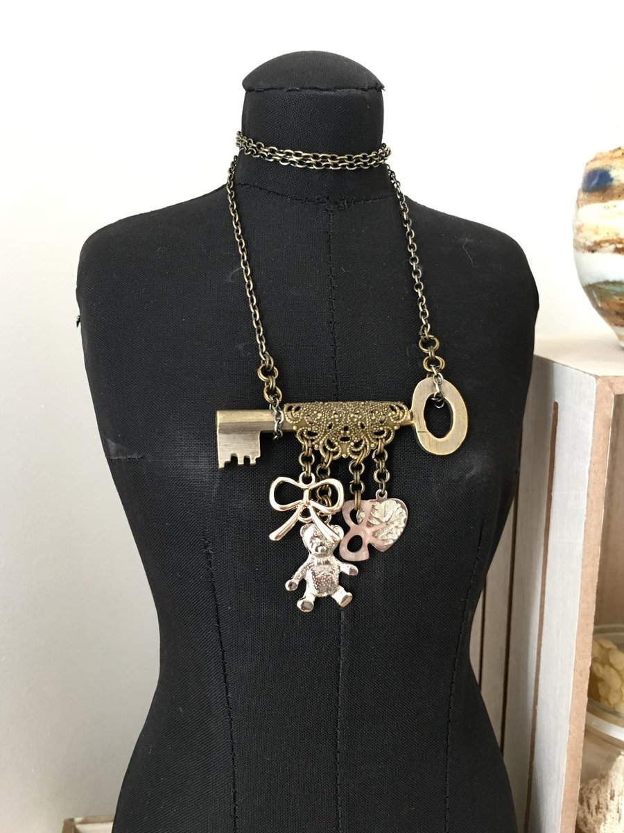 Up-cycled vintage key featured with teddy bear and up-cycled bow charms necklace