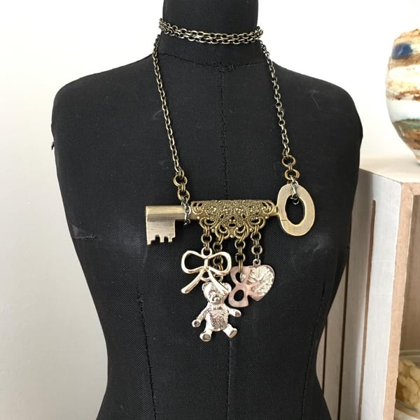 Up-cycled vintage key featured with teddy bear and up-cycled bow charms necklace