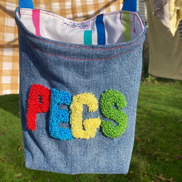 Recycled denim peg bag with blue shoulder strap and embroidered decoration 