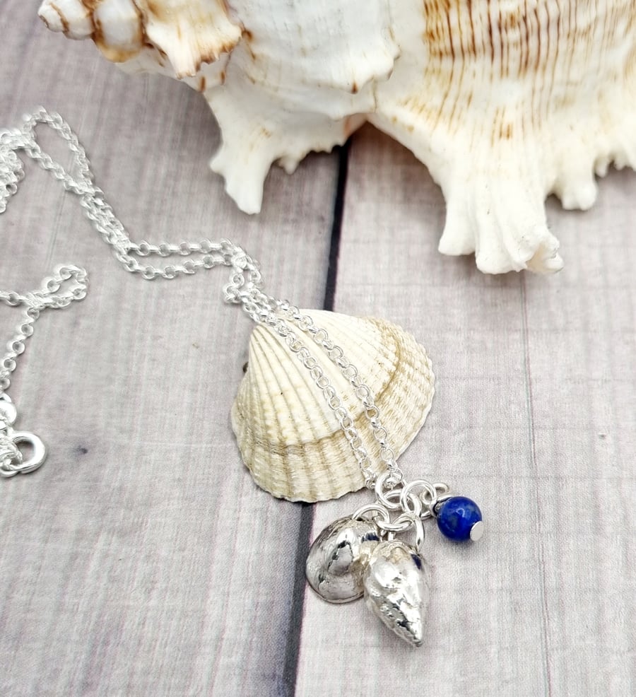 Real shells coated in silver with lapis lazuli bead, unique item!