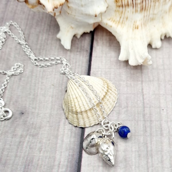 Real shells coated in silver with lapis lazuli bead, unique item!