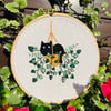 Hand embroidered picture of a Black Cat in a hanging basket of plants. 