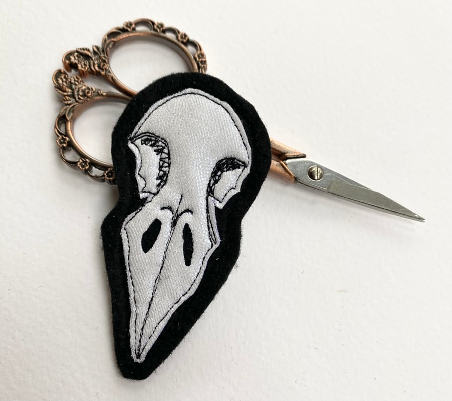 Embroidered bird skull brooch pin of badge. 