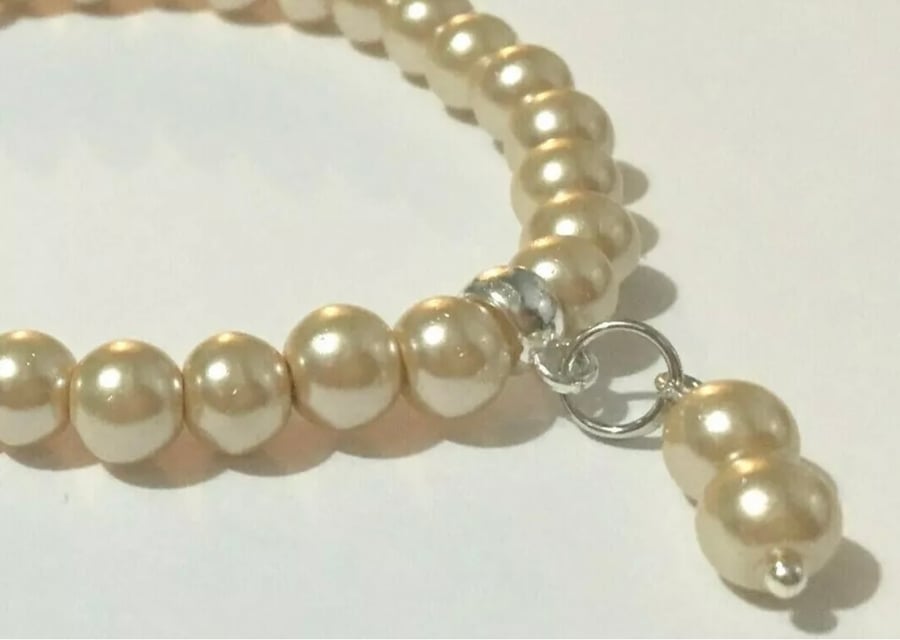 Light Gold Coloured Faux Pearl Stretchy Bracelet with Charm dangle.