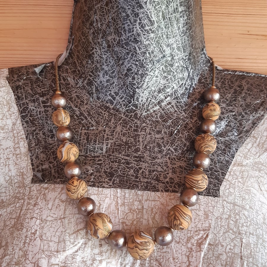 Polymer clay necklace in pastel orange, brown and gold