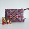 Make up or toiletries bag made from a print with a Folk Art style.