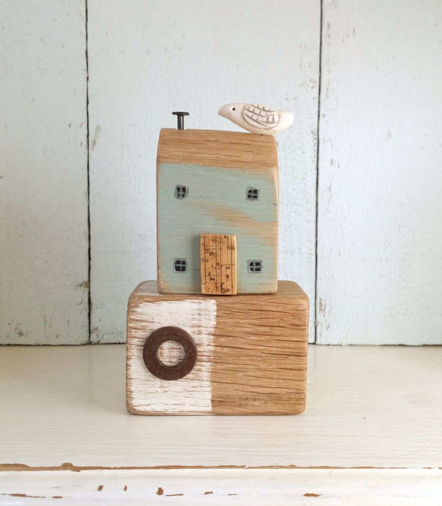 Little wooden seaside house with clay bird