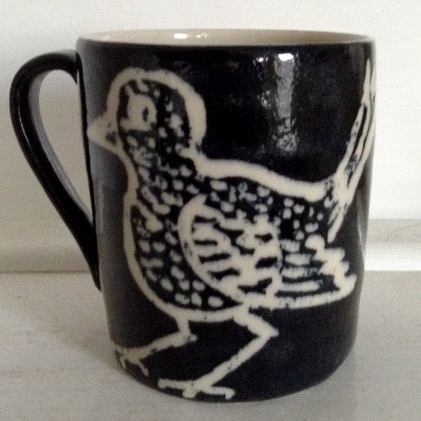 Mug in cream stoneware with black and cream bird decoration.     
